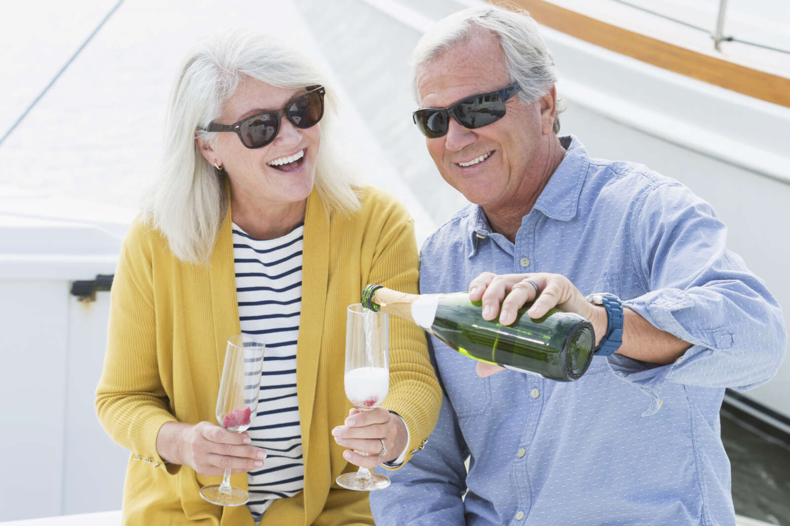 Seniors drinking champagne by a boat